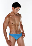 Man wearing blue swim briefs on a white background